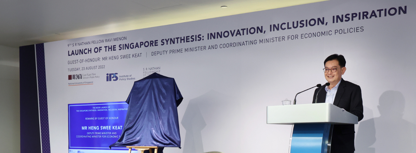 Heng Swee Keat at podium. Unveiling a publication covered in blue cloth. Event backdrop includes sponsor logos.